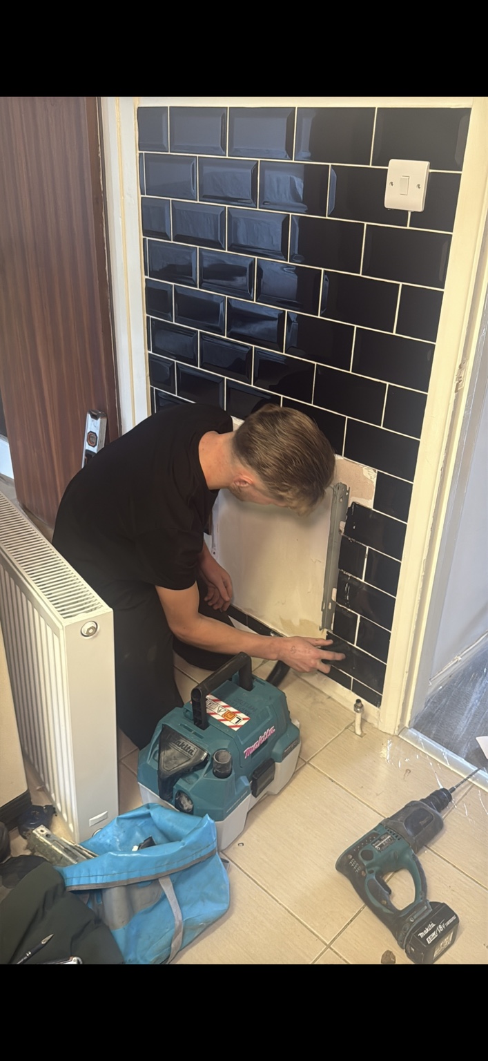 Plumber working on pipework during a bathroom installation