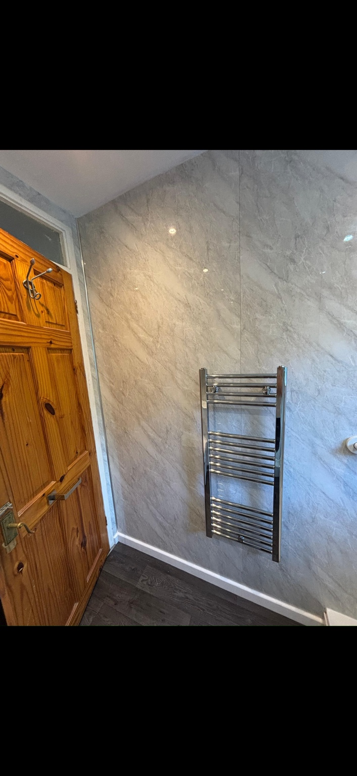 Chrome heated towel rail fitted in the completed bathroom